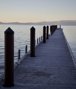 Pier over sea against clear sky during sunset