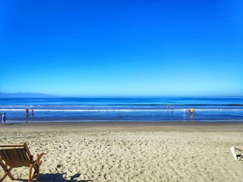 Scenic view of beach against clear blue sky