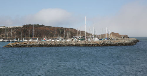 Sailboats in sea against sky