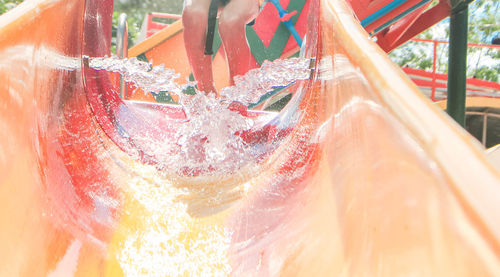 Water splashing in water slide with person in background