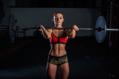 Full length of young woman with arms raised