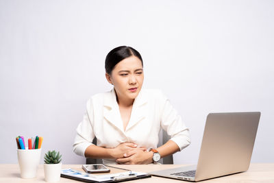 Young woman using mobile phone on table