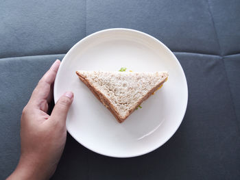 High angle view of person holding bread in plate