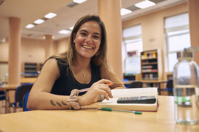 Close-up of a smiling girl in a library looking into the camera