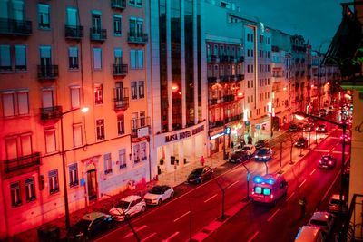 High angle view of traffic on city street and buildings at night