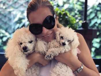 Portrait of smiling woman holding dogs at home