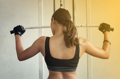 Rear view of woman exercising at gym