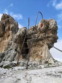 Low angle view of rock formation on land against sky