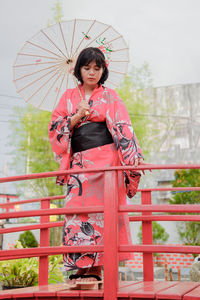 Portrait of young woman holding umbrella