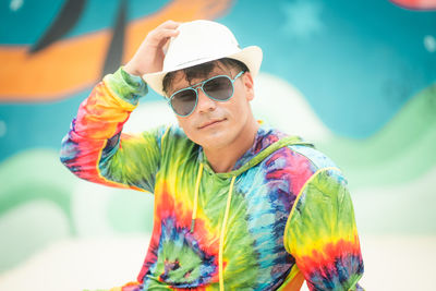 Portrait of young man wearing sunglasses while sitting on stage