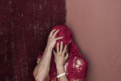 Low section of woman against red wall