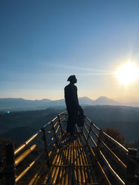 Man standing on mountain against sky during sunrise