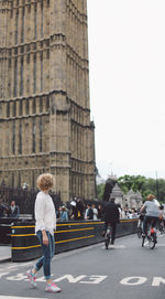 Full length of woman walking on road against big ben