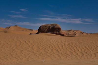 Sand dunes in desert against sky