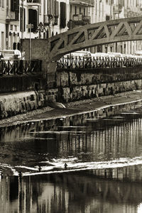 Bridge over river by buildings in city