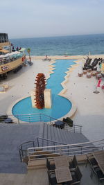 High angle view of swimming pool by sea against sky