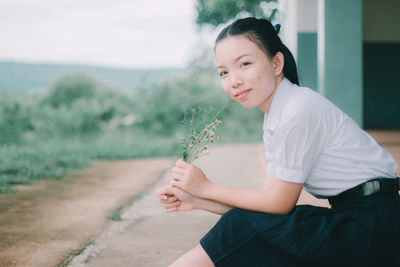 Portrait of woman sitting on plant