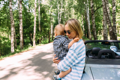 Mom and little son in a convertible car. summer family road trip to nature