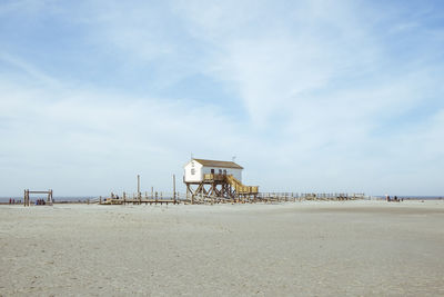 Lifeguard hut on beach by sea against sky