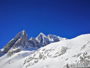 Scenic view of snowcapped mountains against clear blue sky