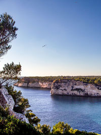 Calm sea against clear blue sky