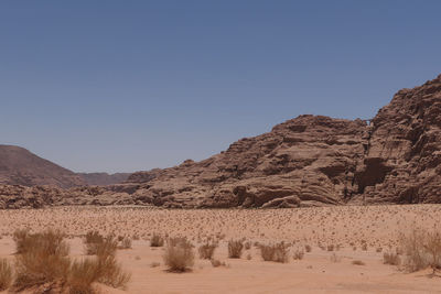 Remote view on arch in mountain range  in wadi rum 