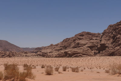 Remote view on arch in mountain range  in wadi rum 