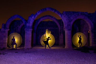 Illuminated lighting equipment on wall at night