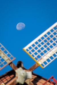 Low angle view of moon against blue sky