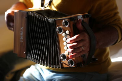 Midsection of man holding camera