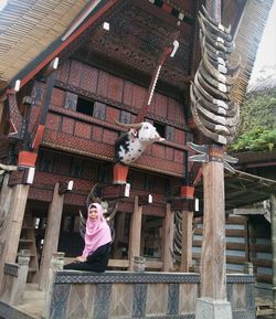 Low angle view of girl against built structure