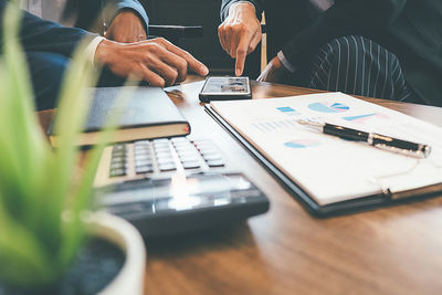 Midsection of man using laptop on table