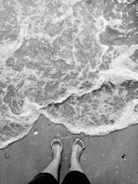 Low section of woman standing on beach