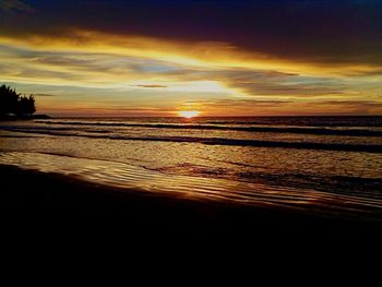 Scenic view of sea against dramatic sky during sunset