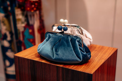 Soft velvet blue and white clutches on a wooden stand. fashion details, women's accessories