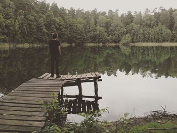 Rear view of man overlooking lake