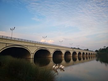 Arch bridge over river against sky