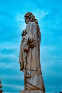 Low angle view of statue against blue sky