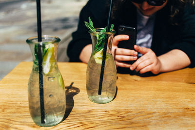 Man photographing lemonade bottles through mobile phone