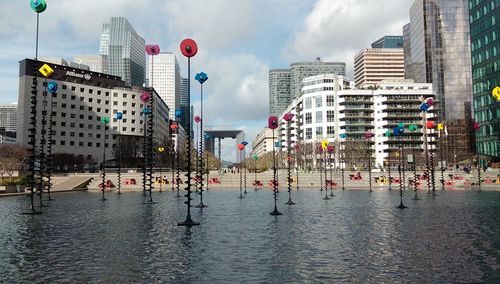 Buildings in city against cloudy sky