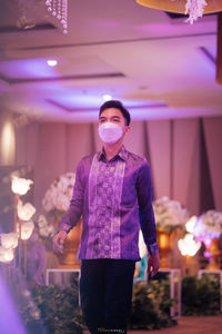 Man wearing mask in illuminated room