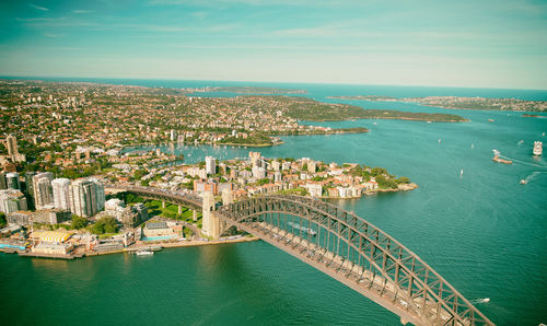 High angle view of city by sea against sky