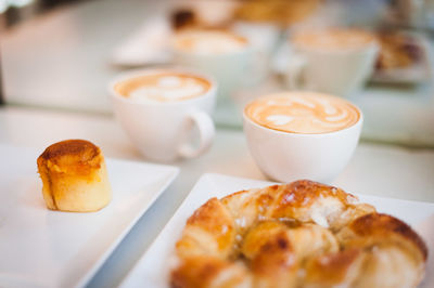 High angle view of dessert with cappuccinos and croissant served on table