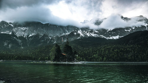 Scenic view of lake by mountains against sky