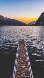 Pier over lake against sky during sunset