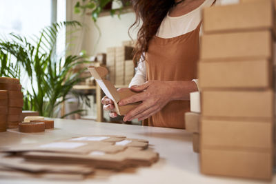 Woman packing soap in brown boxes at workshop