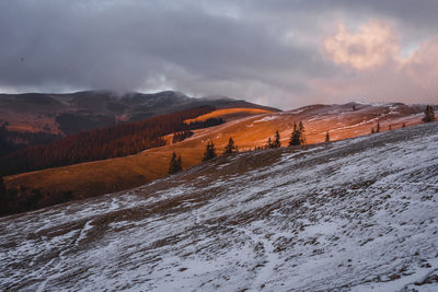 Scenic view of snowcapped mountains against sky during sunset