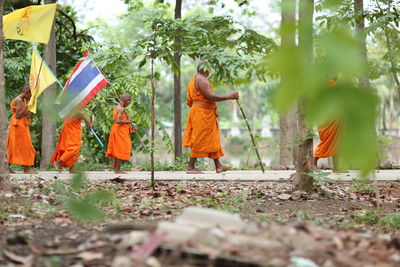 Rear view of people walking in garden