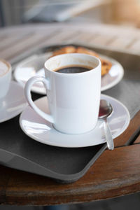 Porcelain cup with coffee on a tablet. mock up offers space for your own designs.