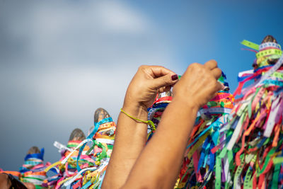 A catholic faithful is seen tying a souvenir ribbon on the railing of the senhor do bonfim church